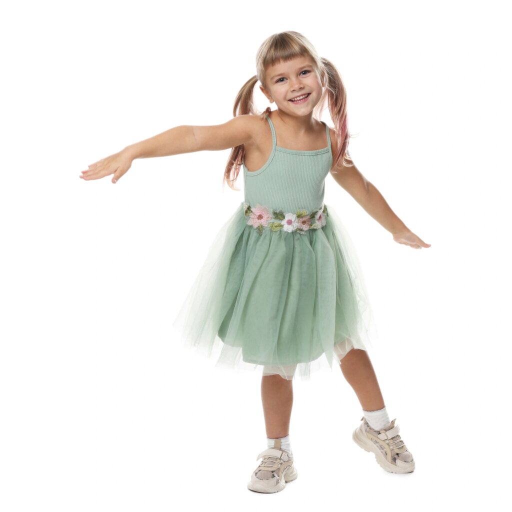 Smiling little girl in dress posing on white background
